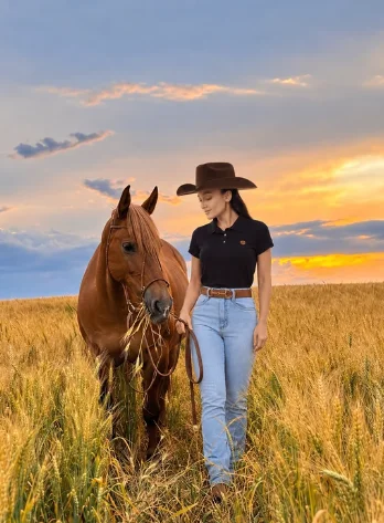 Modelo usando jeans feminino Maragata ao lado de um cavalo no campo