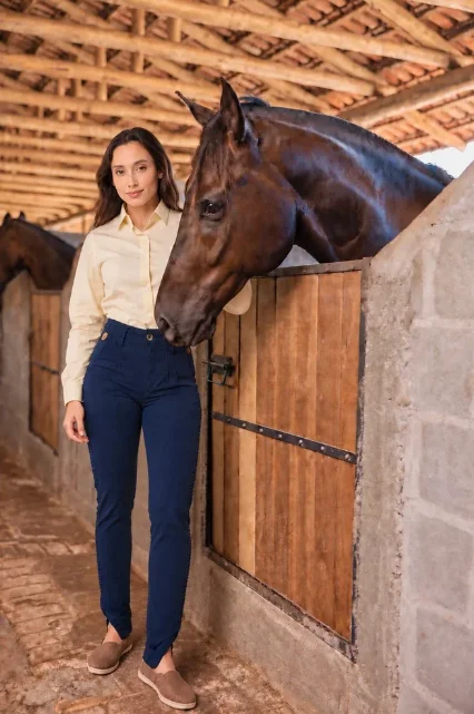 Modelo da coleção Aurora Fria ao lado de um cavalo na cocheira